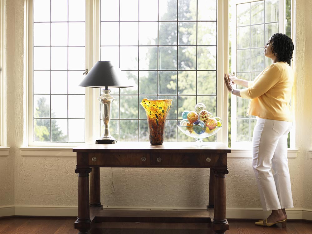 woman opening window to let in fresh air