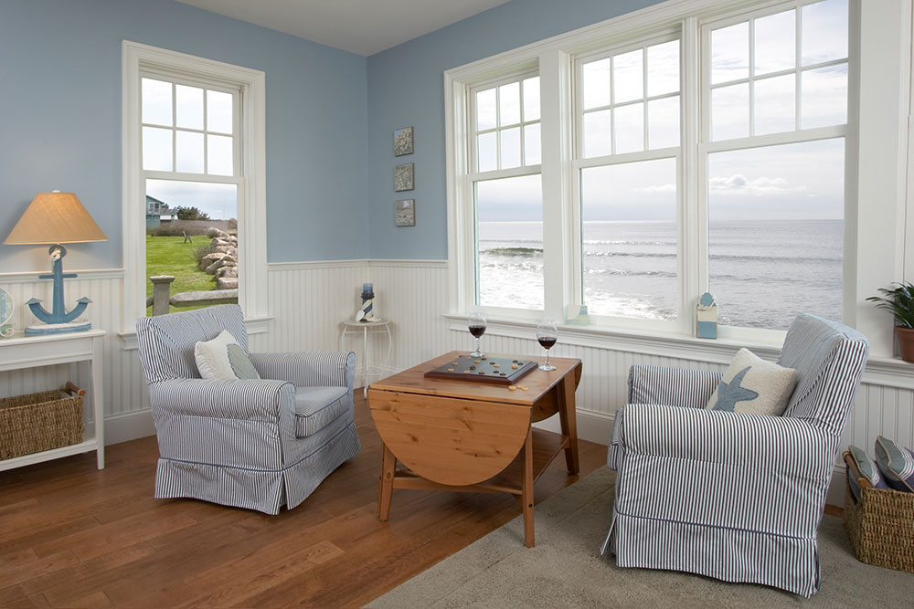 four white windows in house looking out to the sea